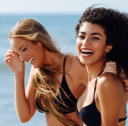 two girls smiling at the beach